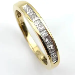 Two-tone gold ring with a channel-set row of square-cut diamonds along the top edge