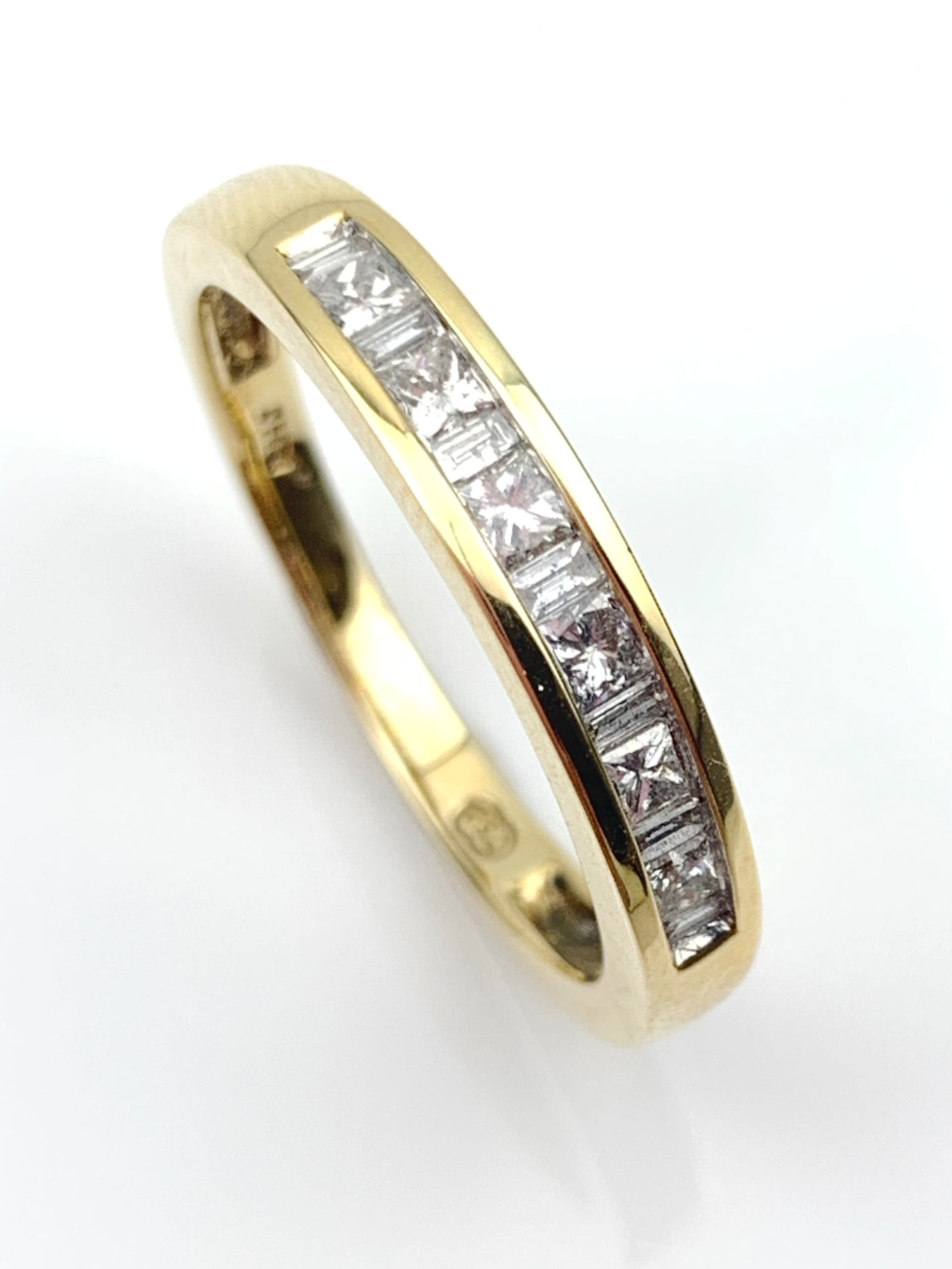 Two-tone gold ring with a channel-set row of square-cut diamonds along the top edge